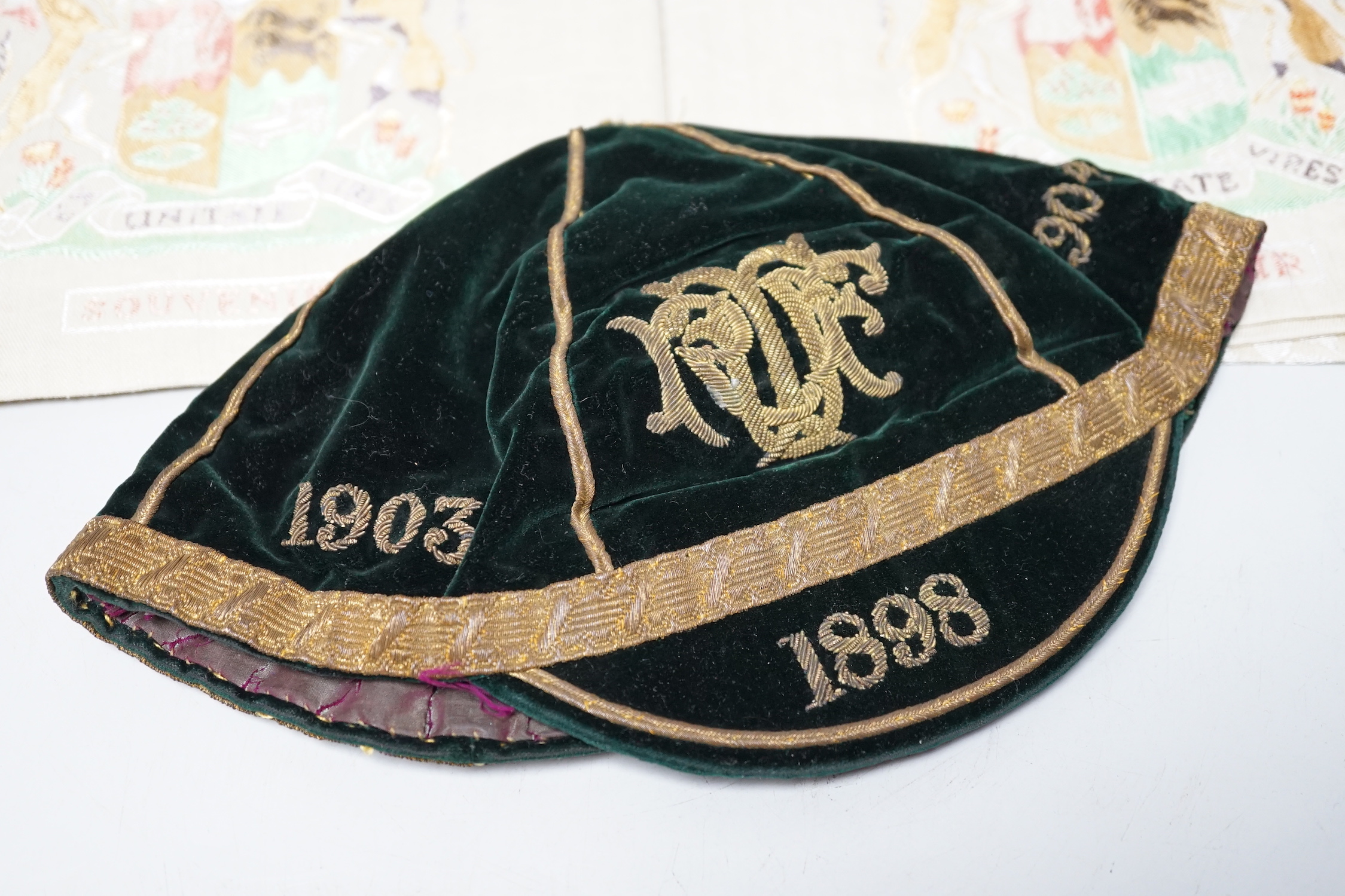 Two South African late 19th century damask railway napkins and a velvet rugby or cricketing cap